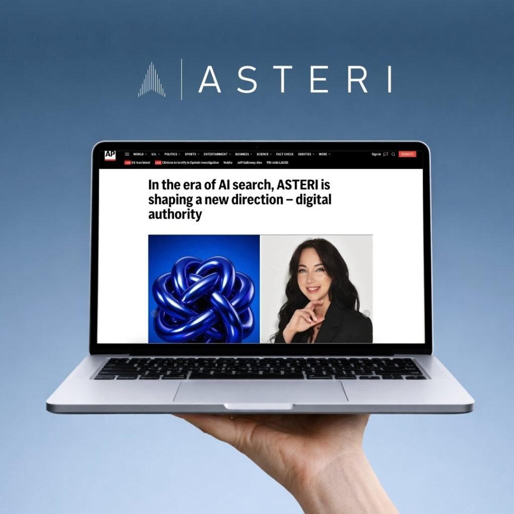 Rankoje laikomas atverstas kompiuteris mėlyname fone, kurio ekrane matoma AP News publikacija apie ASTERI ir skaitmeninę autorystę AI paieškos eroje.